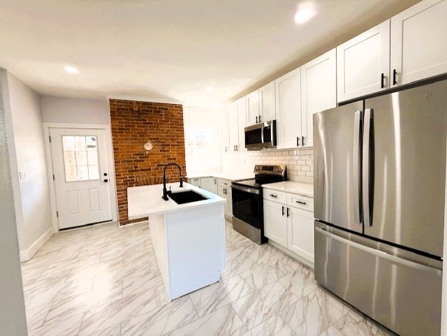 kitchen with backsplash, marble finish floor, stainless steel appliances, and a sink