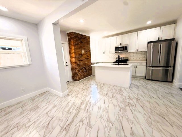 kitchen featuring baseboards, stainless steel appliances, light countertops, white cabinets, and tasteful backsplash