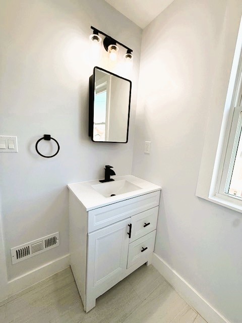 bathroom with visible vents, baseboards, and vanity