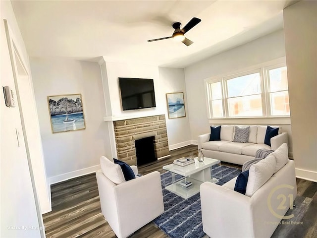 living area featuring baseboards, ceiling fan, and dark wood-style flooring