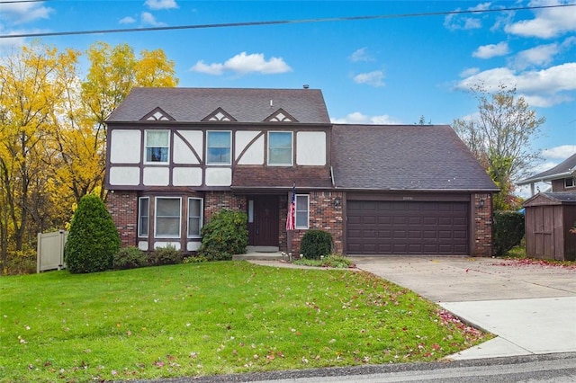 tudor house with a garage, brick siding, concrete driveway, and a front yard