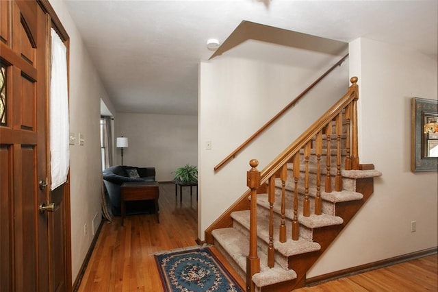 entryway featuring stairway, baseboards, and wood finished floors