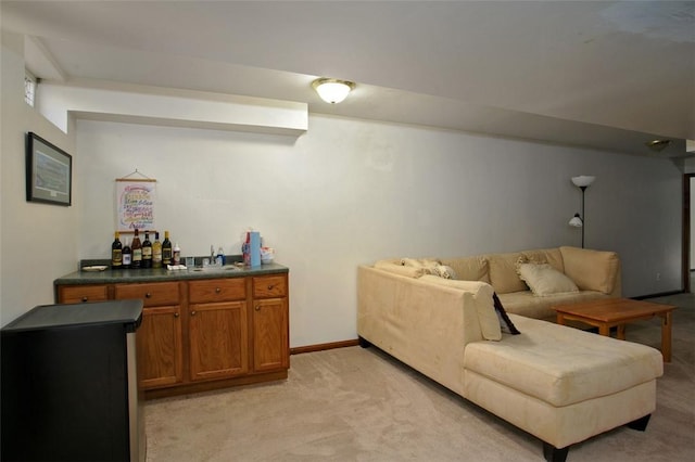 living room featuring baseboards, light carpet, and bar area