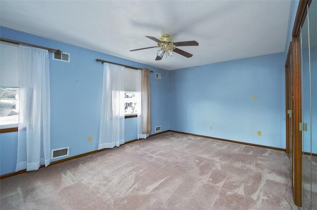 unfurnished bedroom featuring a ceiling fan, carpet, visible vents, and baseboards