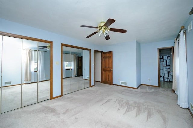 unfurnished bedroom with baseboards, visible vents, multiple closets, and carpet floors