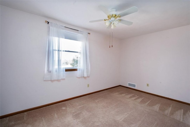 carpeted empty room featuring visible vents, baseboards, and ceiling fan