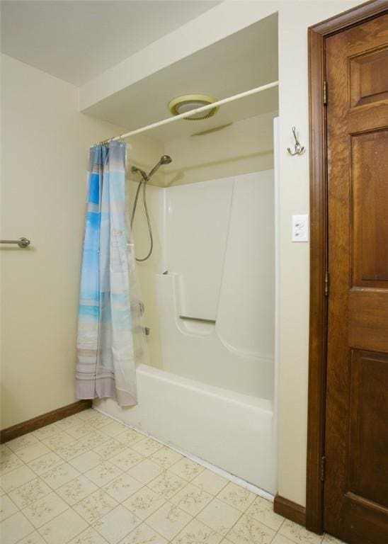 full bath featuring tile patterned floors, baseboards, and shower / tub combo with curtain