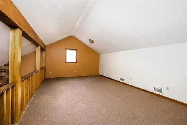 additional living space with light carpet, visible vents, baseboards, and vaulted ceiling