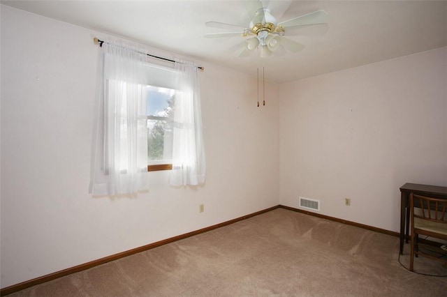 empty room featuring visible vents, carpet floors, baseboards, and ceiling fan