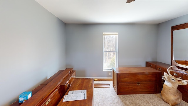 bedroom featuring light carpet and baseboards