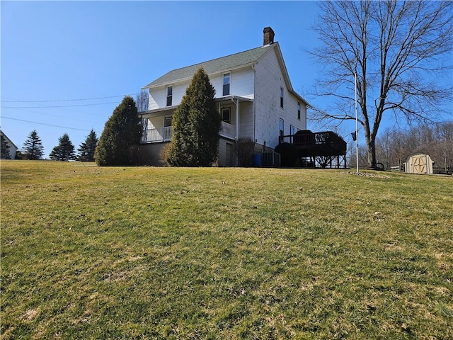 view of side of home featuring a yard, a storage shed, an outdoor structure, and a chimney