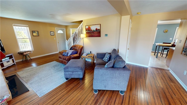 living room featuring stairway, baseboards, and hardwood / wood-style floors