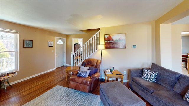 living area featuring stairway, wood finished floors, and baseboards