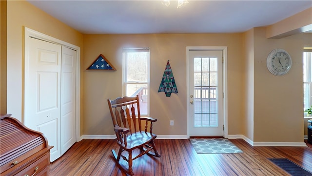 foyer with dark wood-type flooring, visible vents, and baseboards