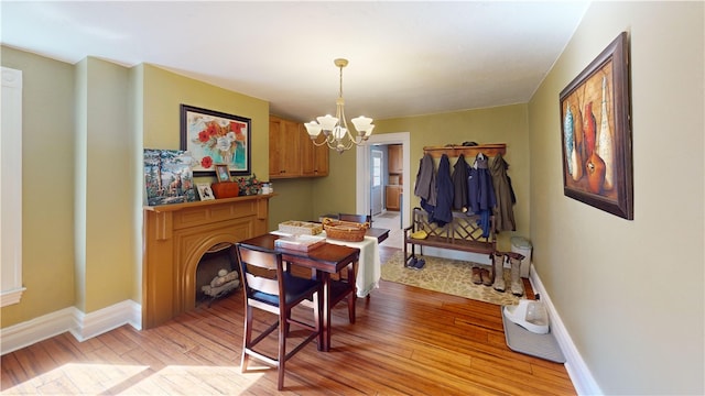 dining room featuring light wood-style floors, baseboards, and a chandelier