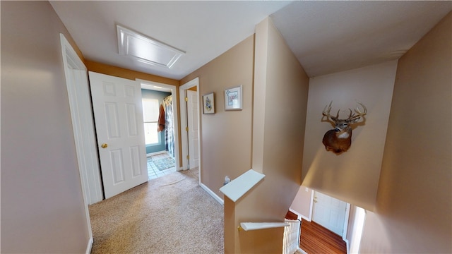 corridor with baseboards and light carpet