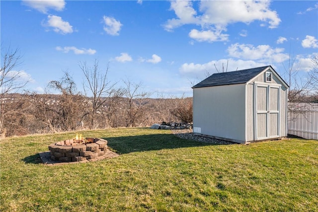 view of yard featuring an outbuilding, a storage shed, fence, and an outdoor fire pit