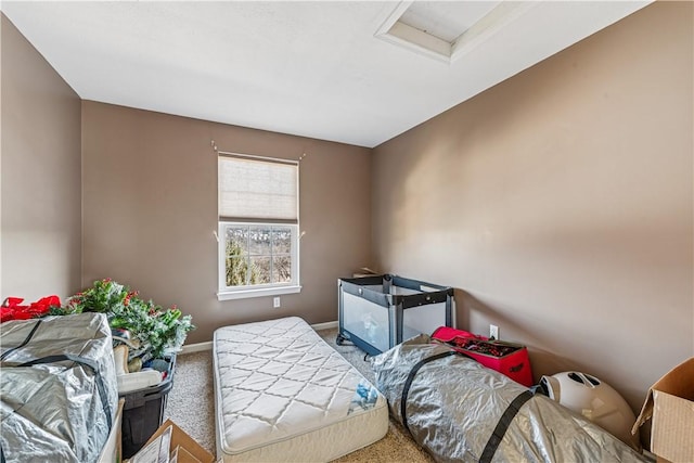 carpeted bedroom featuring baseboards and attic access