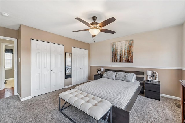 bedroom featuring carpet, baseboards, two closets, and ceiling fan