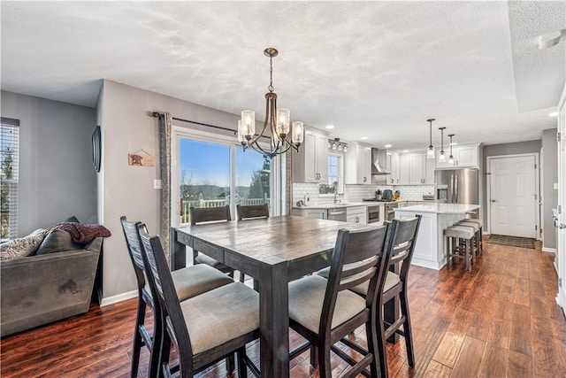 dining area featuring baseboards, a textured ceiling, an inviting chandelier, and dark wood-style flooring