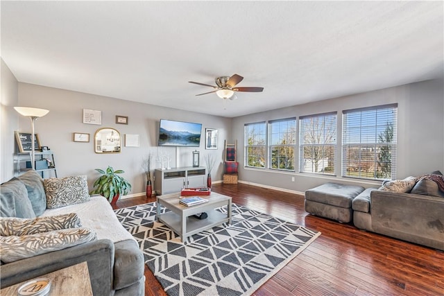 living room featuring baseboards, a ceiling fan, and dark wood-style flooring