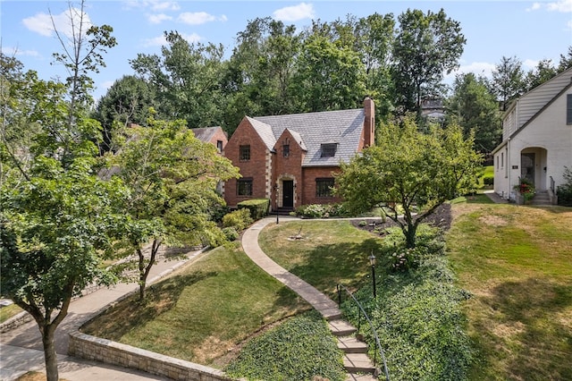 view of front of home with a chimney and a front lawn