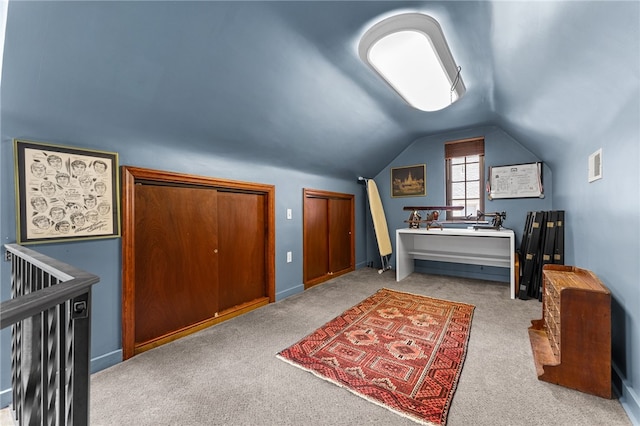 bedroom with visible vents, lofted ceiling, carpet floors, and multiple closets