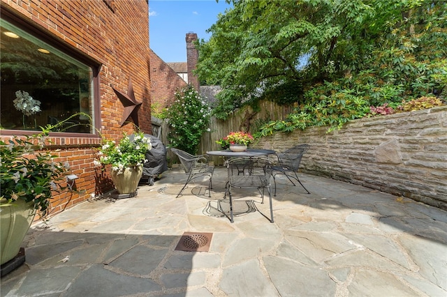 view of patio featuring outdoor dining area and fence