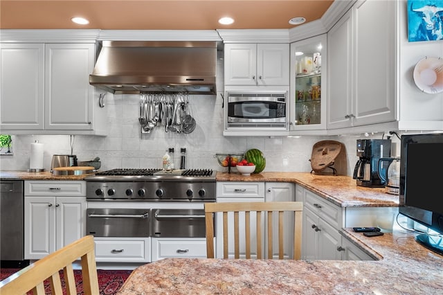 kitchen with decorative backsplash, wall chimney exhaust hood, and white cabinets