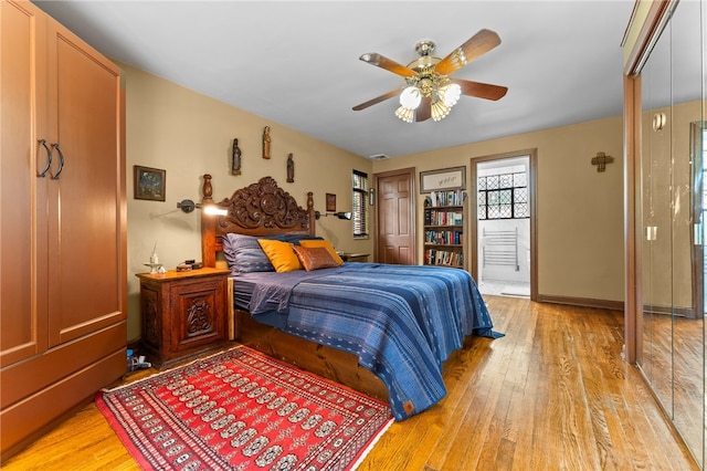 bedroom featuring light wood-type flooring, baseboards, and a ceiling fan