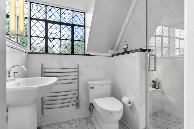 bathroom featuring tile walls, toilet, and a stall shower