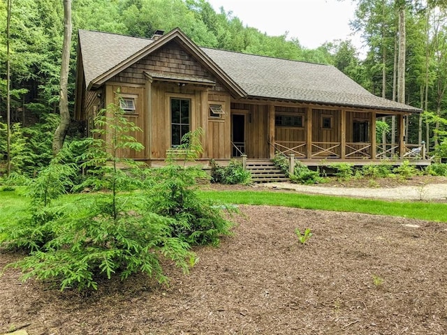 view of front of house featuring roof with shingles and a porch