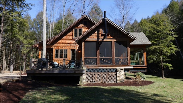 rear view of property featuring roof with shingles, a yard, and a sunroom