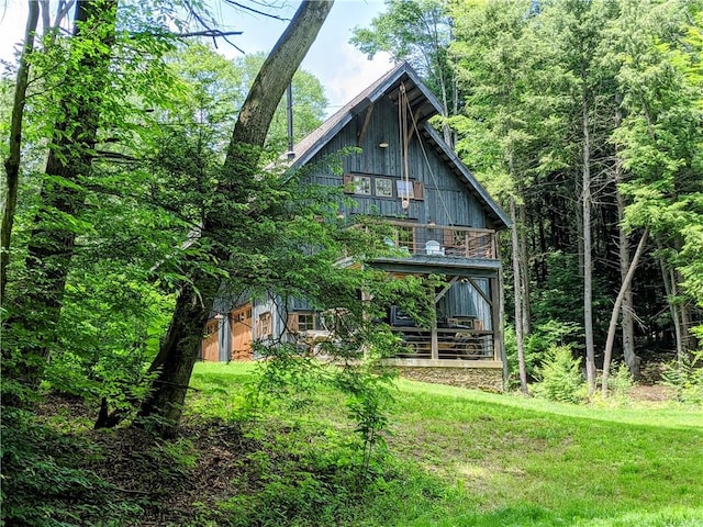 back of house with a balcony and a yard