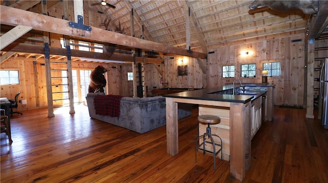 kitchen with wooden walls, dark countertops, and dark wood-style floors