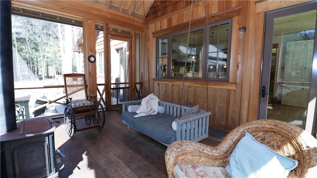 sunroom / solarium with vaulted ceiling and a wood stove