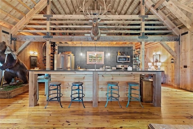 000 Wonder Ln, Punxsutawney Area School District, PA 15767 - kitchen with appliances with stainless steel finishes, light wood-style flooring, high vaulted ceiling, a wood ceiling with exposed beams, and wooden walls