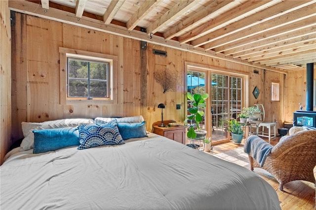 000 Wonder Ln, Punxsutawney Area School District, PA 15767 - bedroom with access to exterior, multiple windows, a wood stove, wooden walls, and wood finished floors