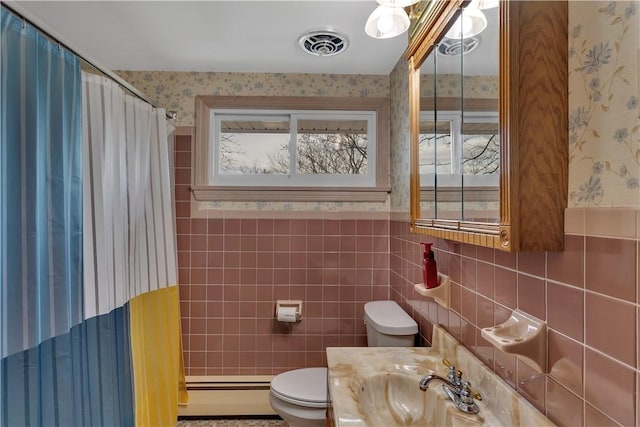 bathroom featuring visible vents, toilet, a wainscoted wall, and wallpapered walls