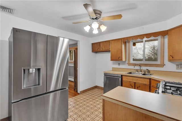 kitchen featuring visible vents, a sink, light countertops, appliances with stainless steel finishes, and baseboard heating