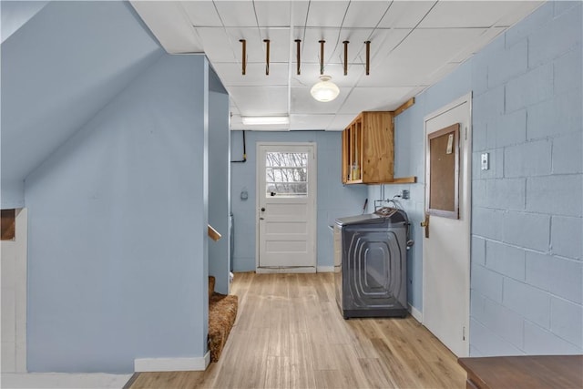 laundry room with cabinet space, washer / clothes dryer, concrete block wall, and light wood finished floors