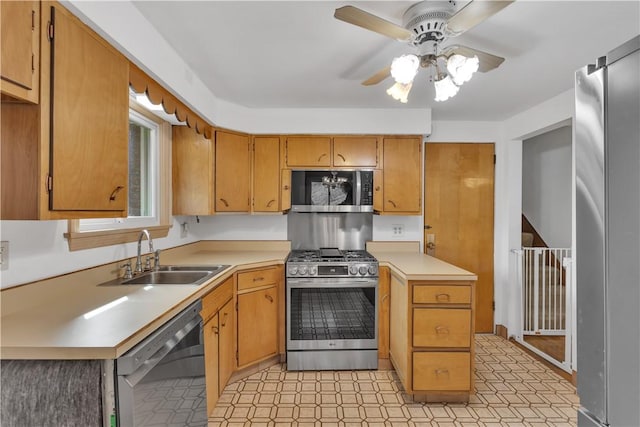 kitchen featuring light floors, light countertops, appliances with stainless steel finishes, a ceiling fan, and a sink