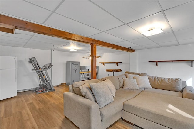 living room featuring concrete block wall, a paneled ceiling, and light wood-type flooring