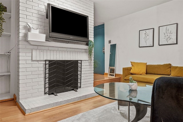 living room with a fireplace and wood finished floors