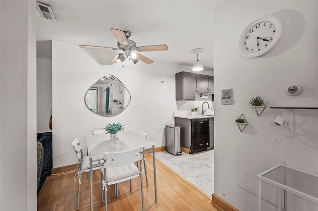 dining space featuring visible vents, light wood-style flooring, baseboards, and ceiling fan