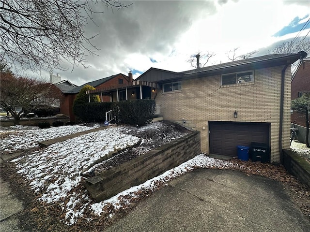 single story home featuring brick siding, an attached garage, and driveway