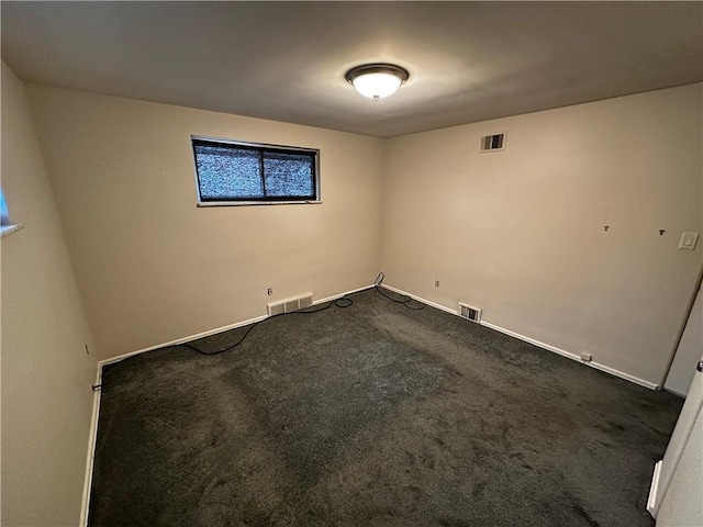 empty room featuring dark colored carpet and visible vents