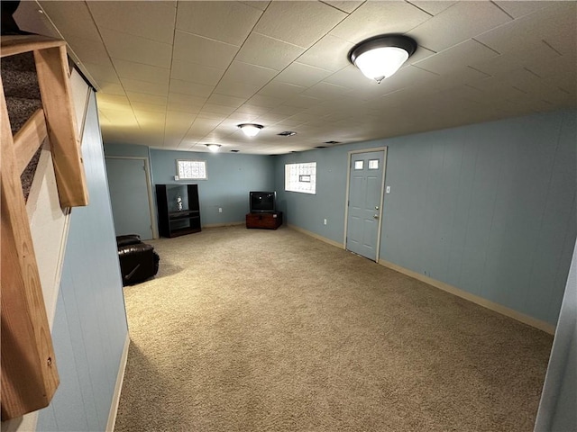 below grade area featuring carpet flooring and baseboards