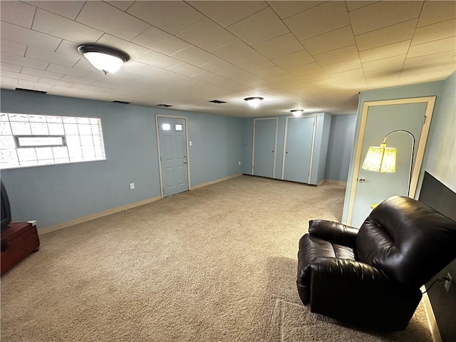 living area featuring light carpet and baseboards