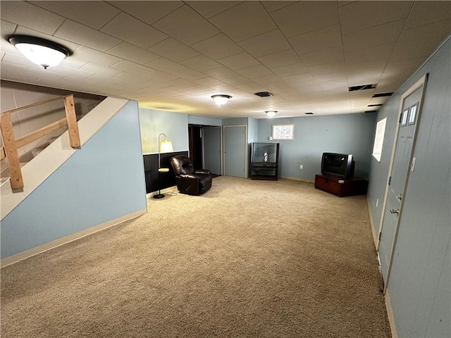 interior space with visible vents, light carpet, baseboards, and stairway